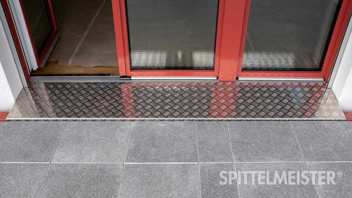 Stahl-Systembalkone in orange Riffelblech als Türschwelle